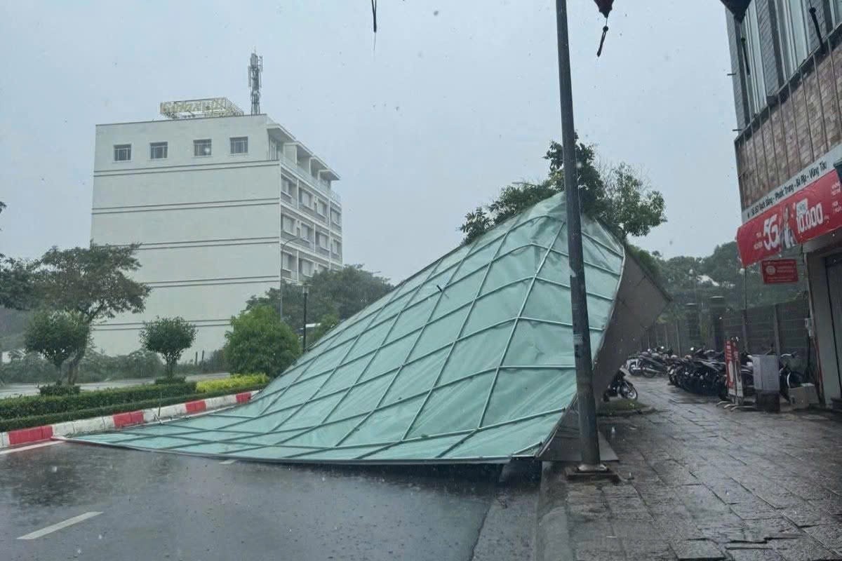 Một bảng hiệu lớn trên đường Bạch Đằng (phường Bà Rịa) bị dông lốc giật văng ra đường vào chiều 20-7. Ảnh: THÀNH AN