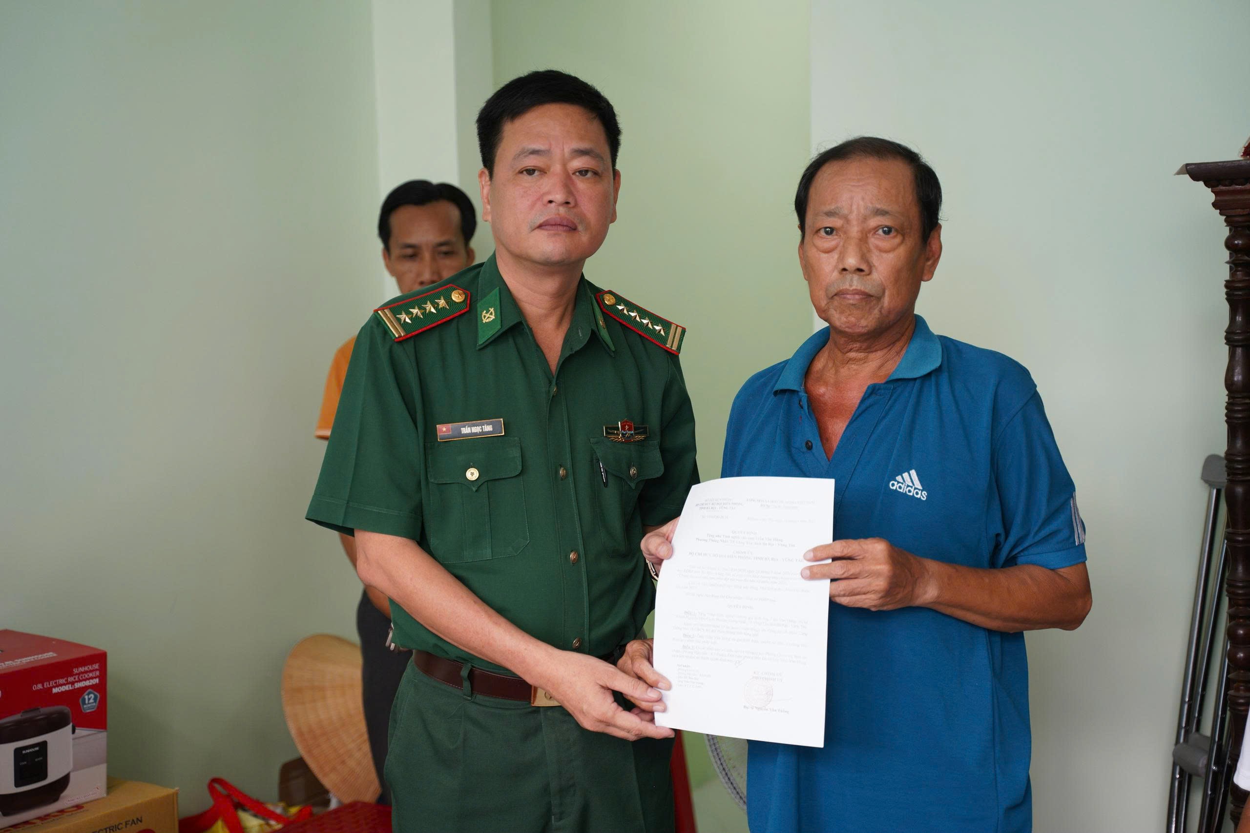 Đại tá Trần Ngọc Tăng, Phó Chỉ huy trưởng Ban Chỉ huy Bộ đội biên phòng TP.Hồ Chí Minh trao quyết định bàn giao Nhà tình nghĩa cho ông Trần Văn Hùng.