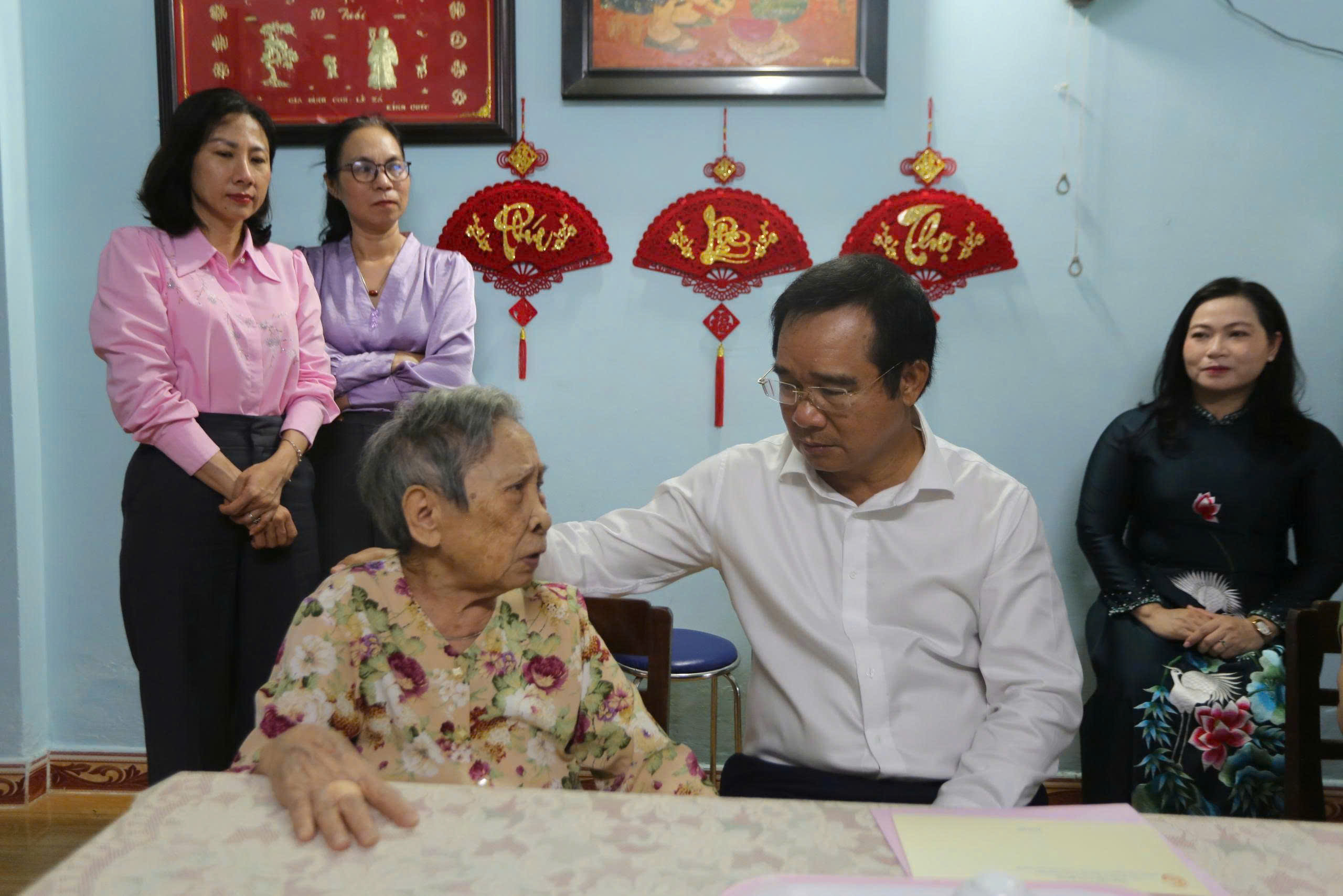 Ông Nguyễn Văn Được, Chủ tịch UBND TP Hồ Chí Minh ân cần thăm hỏi bà Võ Thị Thanh - vợ liệt sĩ.