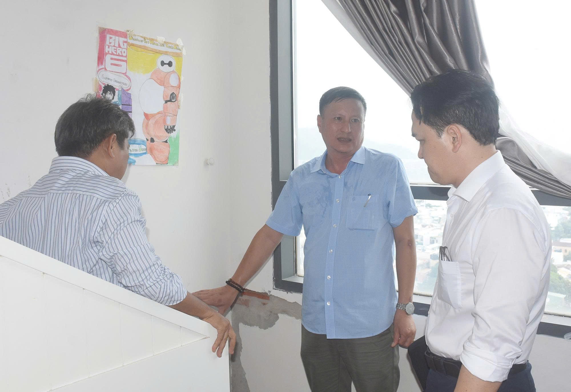  Ông Nguyễn Thanh Xuyên, Trưởng Phòng Quản lý chất lượng công trình xây dựng - Sở Xây dựng TPHCM (bìa phải) trực tiếp kiểm tra tình trạng nứt tường tại căn hộ 16-08 chung cư Lapen. Ảnh: QUANG VŨ