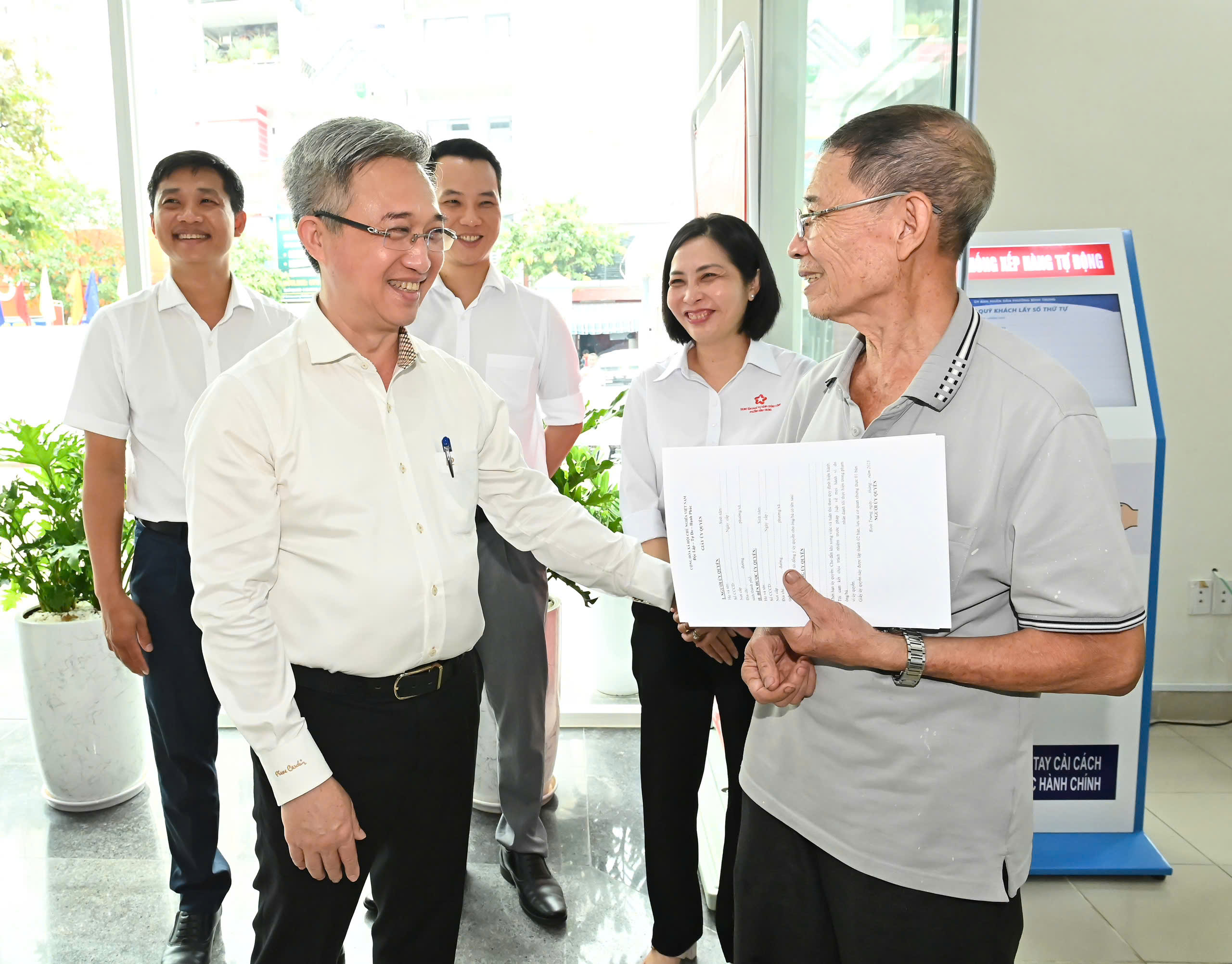 Đồng chí Đặng Minh Thông trao đổi cùng người dân tại Trung tâm Phục vụ hành chính công phường Bình Trưng. Ảnh: VIỆT DŨNG