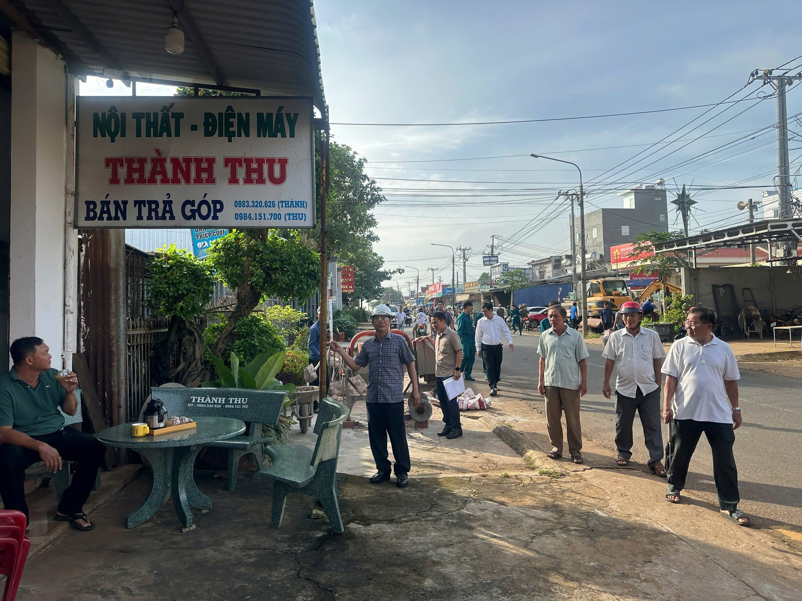 Chủ tịch UBND xã Xuân Sơn Ngô Văn Luận (bên trái) và các lực lượng chức năng nhắc nhở các hộ kinh doanh thu gọn mái hiên, biển quảng cáo lấn chiếm hàng lang ATGT trên tuyến đường Mỹ Xuân - Ngãi Giao - Hòa Bình.