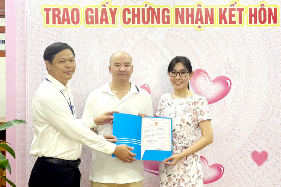 Ông Ngô Thanh Phúc, Phó Bí thư Đảng ủy, Chủ tịch UBND xã Long Hải trao giấy chứng nhận kết hôn cho chị Nguyễn Vũ Thục Nhàn, quốc tịch Việt Nam và anh Nguyễn Đức Thông, quốc tịch Australia.