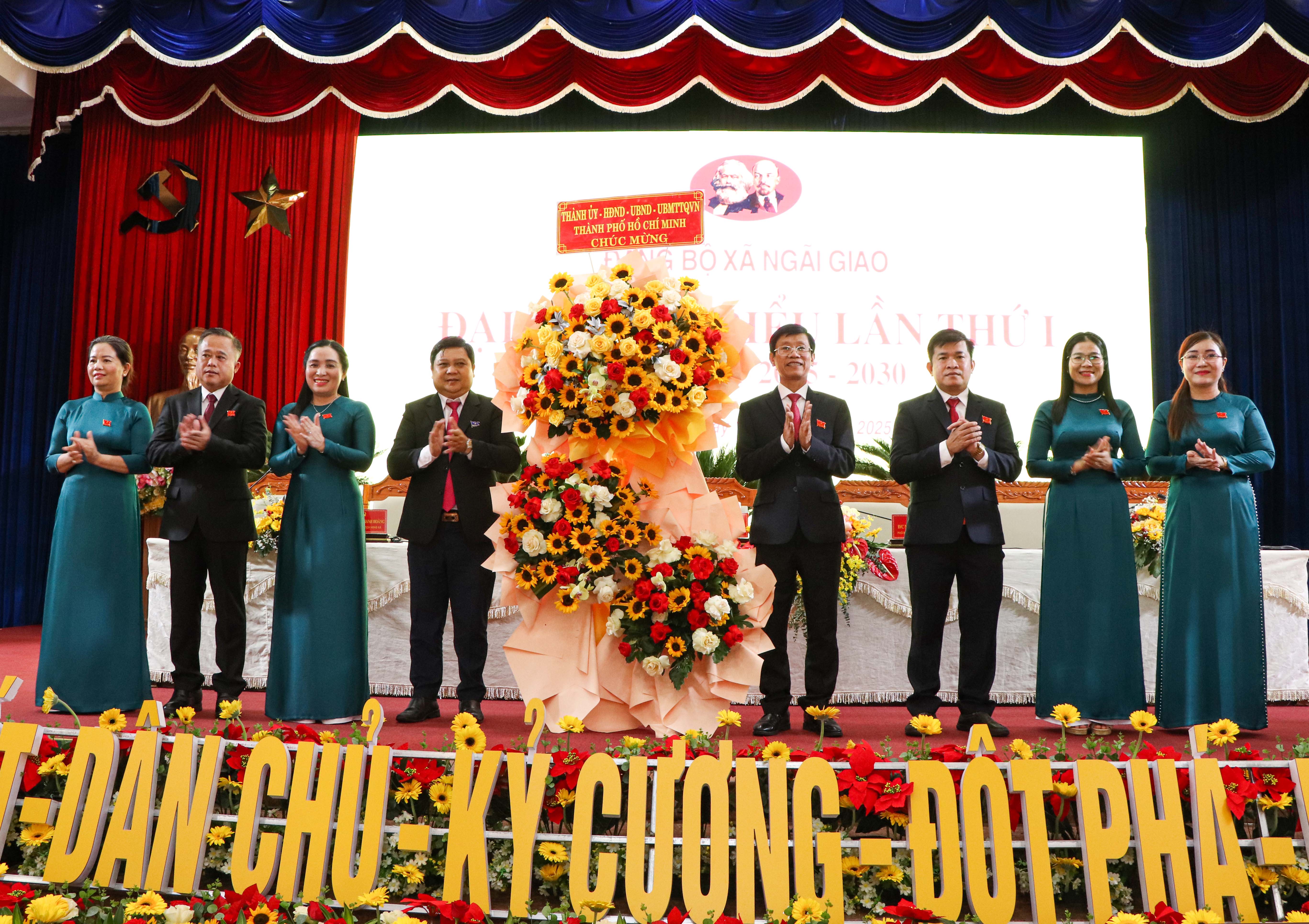 Đồng chí Nguyễn Chí Trung (thứ 4 từ trái vào), tặng hoa của Thành ủy TPHCM chúc mừng Đại hội xã Ngãi Giao. Ảnh ĐINH HÙNG