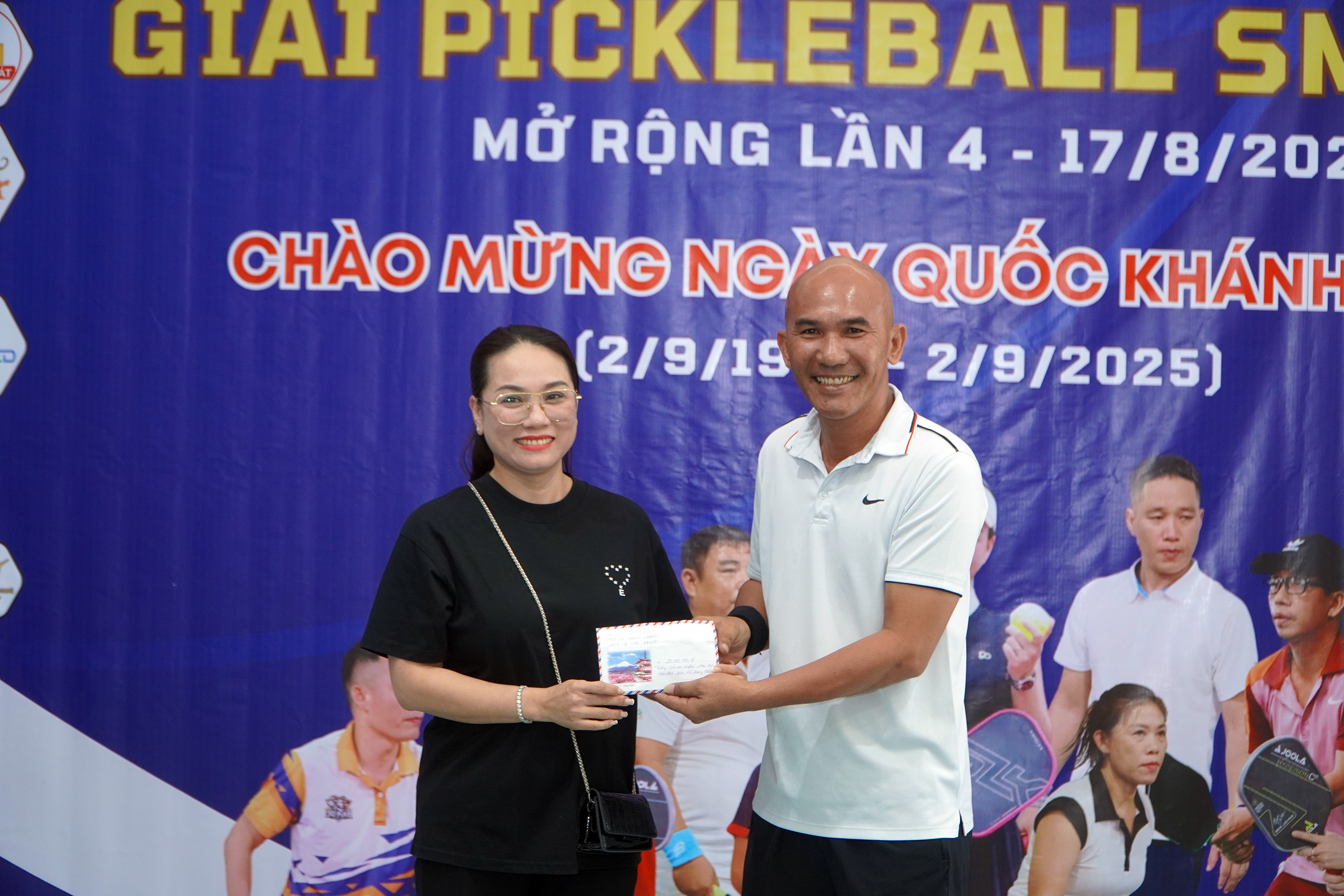 Đại diện ban tổ chức giai tặng 20 triệu đồng cho người có hoàn cảnh khó khăn tại địa phương đến đại diện lãnh đạo Ủy ban MTTQ Việt Nam xã Long Hải.