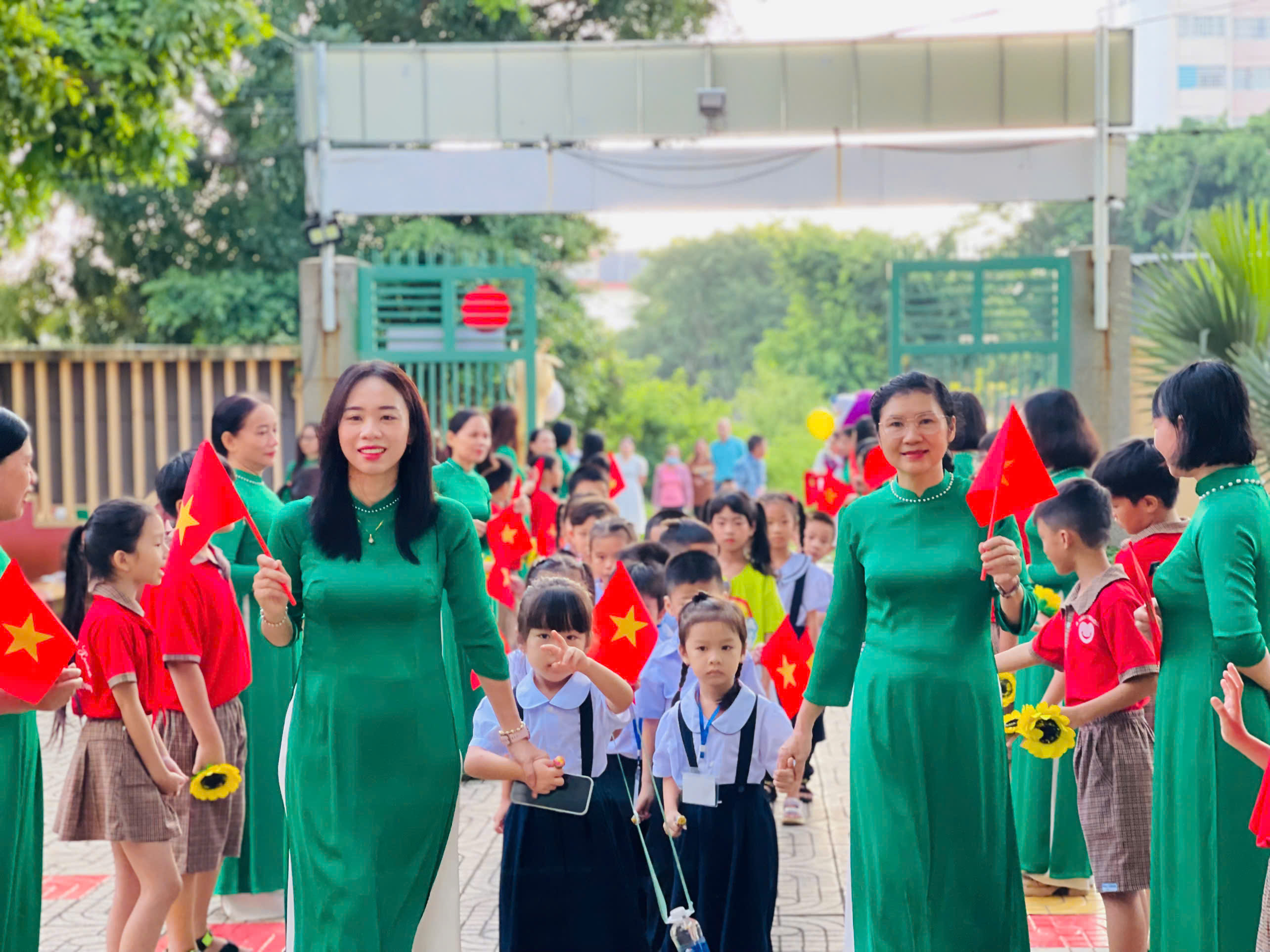 Cô giáo dắt tay học sinh lớp 1 đến tận từng lớp học.